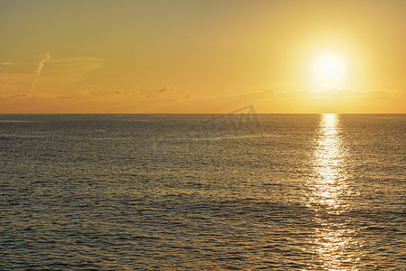 水底慢慢升起的气泡摄影照片_太阳从平静的海面上升起，云彩变成橙色