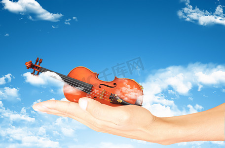在天空和云彩背景的大提琴