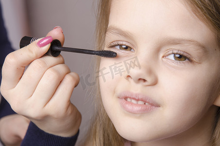 化妆师在女孩脸上画睫毛