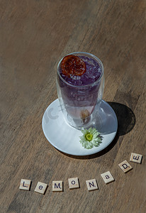 一杯加柠檬水的苏打饮料、橙汁混合蝴蝶豌豆汁 (Anchan) 冷清爽饮料或木桌上加冰的饮料。
