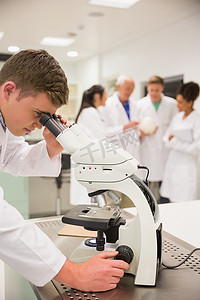 使用显微镜的年轻医科学生