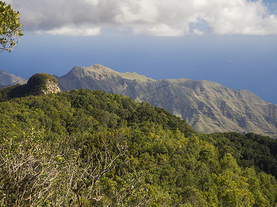 西班牙特内里费岛加那利岛阿纳加山的 Amogoje 观景台，拥有皮托雷斯克的绿色山丘和灌木、尖锐的岩峰和大海，拥有戏剧性的蓝天白云背景