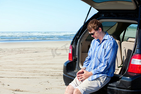 在海滩上开车的白人男子，不开心，担心的表情