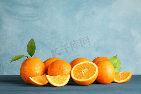 浅色背景下，木桌上有叶子的熟橙子，文字空间