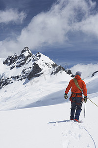 下雪安全摄影照片_雪山安全线连接男性徒步者的后视