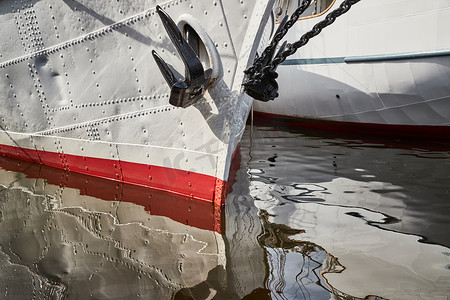 鼻部摄影照片_一艘白色帆船的鼻部，鼻子上有锚，水中有明亮的反射
