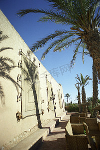 建筑外墙摄影照片_建筑外墙有棕榈树和柳条家具