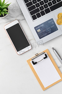使用信用卡、智能手机、办公桌上的笔记本电脑查看财务计划概念。