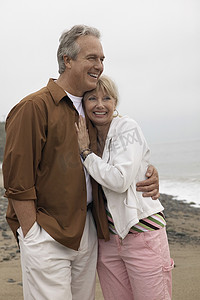 恩爱的中年夫妇在海滩上互相拥抱