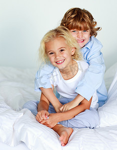 床上的男孩摄影照片_床上的小女孩和男孩