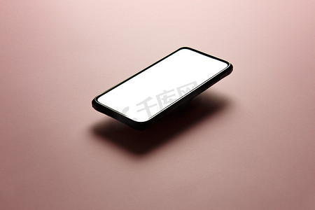 平面色彩摄影照片_手机的简约模拟平面图像设计，带有复制空间和白色屏幕，可以在平面柔和的粉红色背景上书写