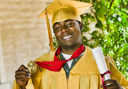 毕业那天有文凭和奖章的自信男学生画像
