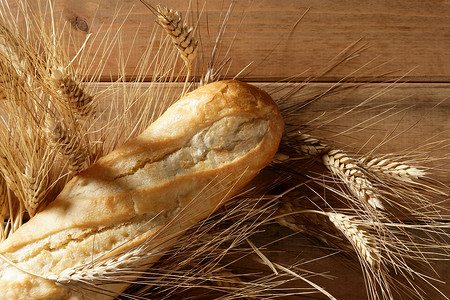 在木桌上放面包，上面放着小麦穗