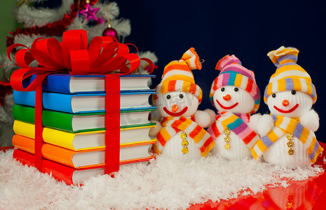 一堆用丝带和三个雪人绑起来的彩色书籍