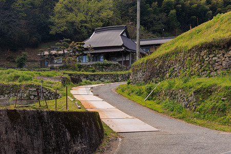 古石墙窄路通往乡村日式传统住宅