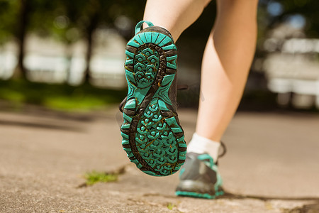 穿跑鞋摄影照片_穿跑鞋的女人在路上慢跑