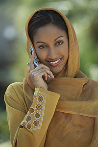 一位身着传统服饰的美丽印度女性使用手机的肖像