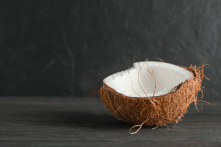 黑色背景下木桌上的半热带椰子，文字空间