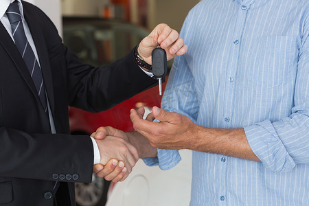 商人在与顾客握手时给车钥匙