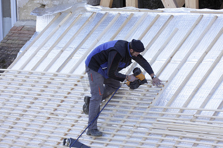 盖屋顶的人摄影照片_盖屋顶的人在用木头建造新屋顶