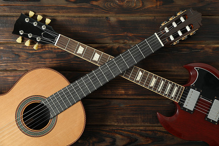 古典背景中摄影照片_木制背景中的电吉他和古典吉他，顶视图