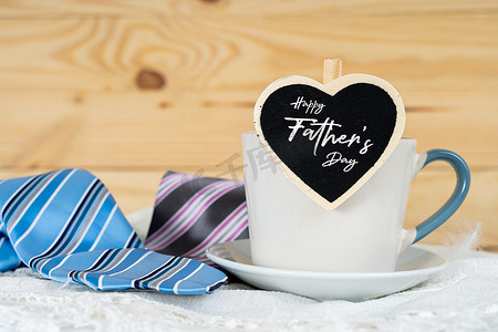 父亲节快乐背景概念与一杯茶，黑色心形和蓝色和粉色领带在木制背景上，带有文本复制空间。