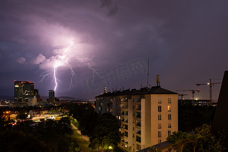 维也纳维纳贝格市上空出现猛烈的夏季雷暴和巨大的闪电，图片右侧有建筑起重机