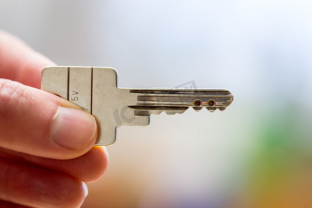 搬进新家：拿着钥匙的手的特写。