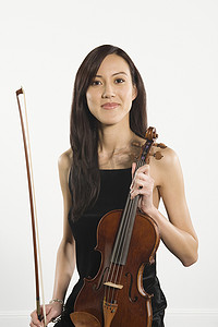 美丽的女性拿着小提琴和小提琴的肖像隔离在白色背景
