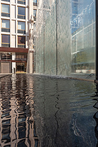 有水的现代喷泉飞溅在一个巨大的玻璃窗上