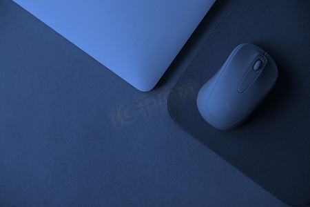 蓝色背景中带笔记本和鼠标垫的电脑鼠标