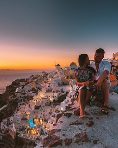 希腊圣托里尼岛摄影照片_希腊圣托里尼岛，在希腊圣托里尼岛度假的情侣男女参观了伊亚圣托里尼的白色​​村庄