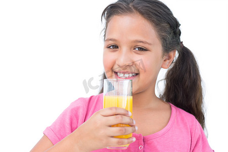 喝橙汁的微笑的小女孩