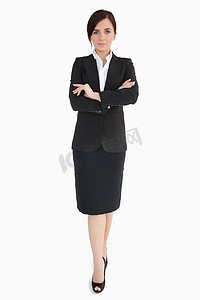 黑色背景摄影照片_交叉双臂穿黑色西装的女人
