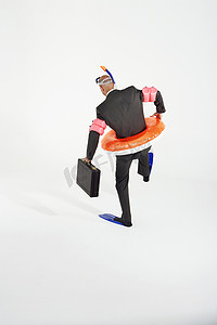 一位身穿脚蹼、充气橡胶圈、通气管和护目镜的商人的后视图，白色背景下拿着公文包