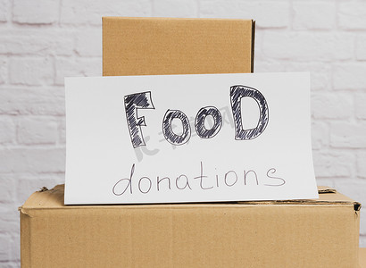 一堆纸箱和白纸，上面写着食物捐赠