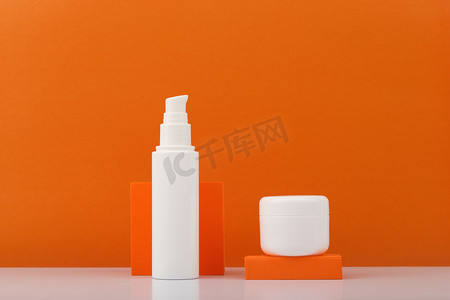 面霜或乳液，在眼霜或血清下，带有柑橘提取物，带有复制空间的橙色背景。