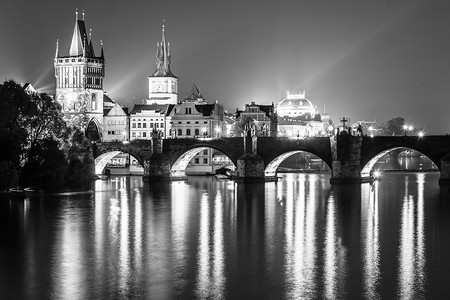 伏尔塔瓦河和查理大桥与旧城桥塔在夜间，布拉格，捷克。