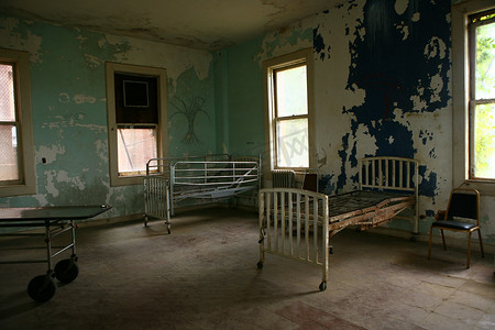 破旧黄色摄影照片_破旧的医院大楼与空生锈的病床