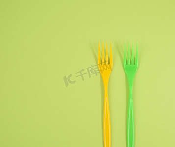 绿色背景中的一堆塑料叉子