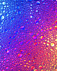 漂亮的彩虹摄影照片_在水面上五颜六色的油滴的顶部视图。
