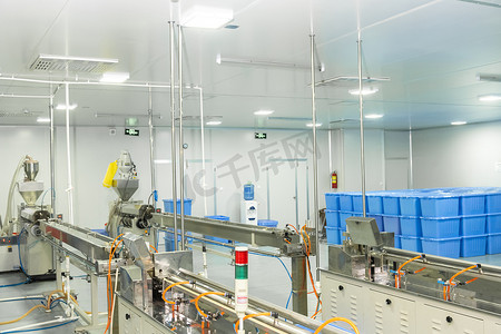 一家生产医用注射器和滴管的工厂，背景是设备和蓝色容器