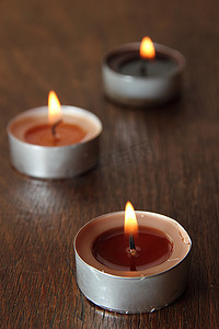 棕色调摄影照片_棕色调的三支蜡烛。