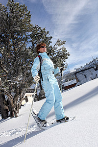 女滑雪者在雪中行走的全身照