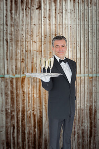高级木板摄影照片_侍者提供带香槟杯的托盘的复合图像