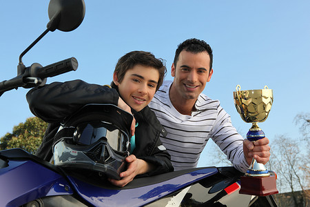 赢得摄影照片_赢得摩托车赛车杯的男孩