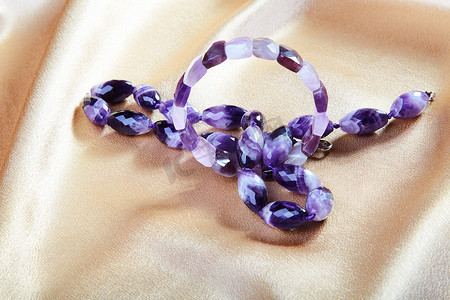 紫色玻璃制成的珠子和手镯与织物相映成趣