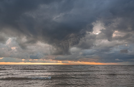海上暴风雨摄影照片_在日落期间的剧烈的乌云在海上