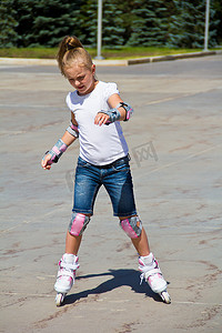 蓝色溜冰鞋摄影照片_学习溜冰鞋的女孩