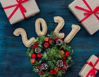 复古包装纸摄影照片_.2021年针织数字、礼品和装饰花环的圣诞背景
